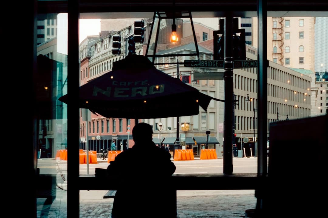 A silhouette seen through a softly lit café window