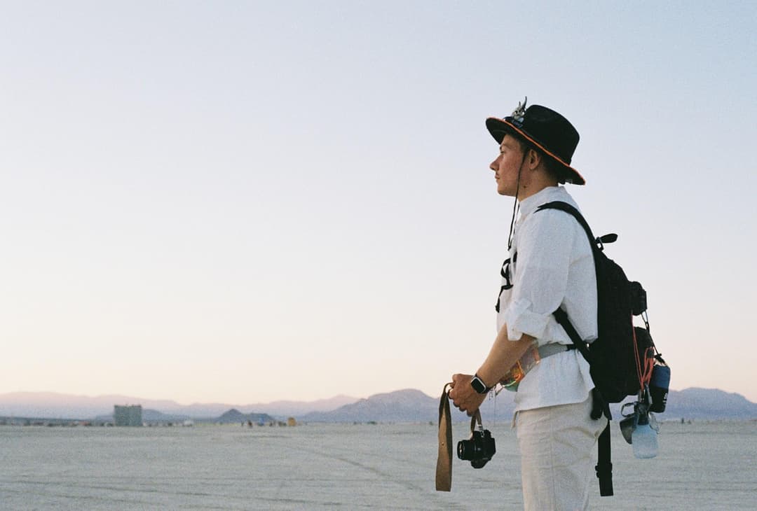 A lone photographer standing in a wide desert landscape