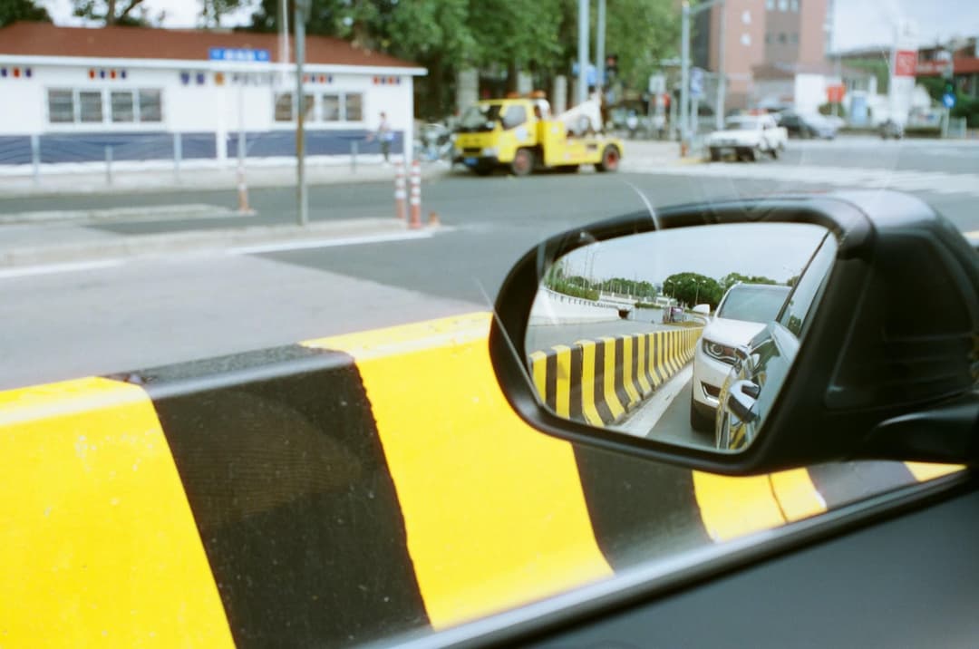 An open road reflected in a car rear-view mirror