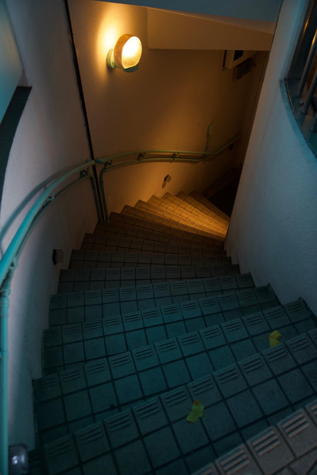 Teal stairs, amber light – Tokyo, Japan